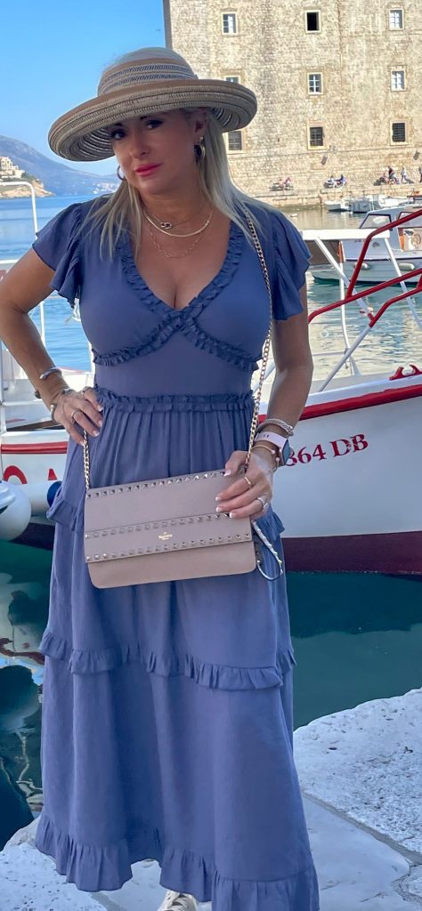 Stylish woman in a pretty dress with luxury designer bag. Dubrovnik, Croatia